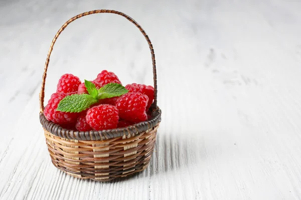 新鲜红树莓在柳条篮子里木背景 — 图库照片