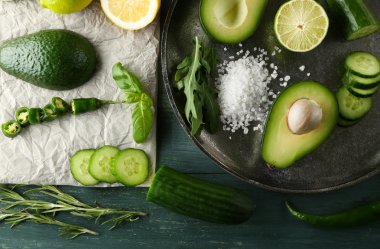 avokado, salatalık, biber ve limon kireç ahşap arka plan üzerine dilimlenmiş