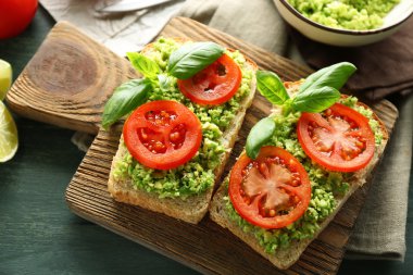 avokado ve ahşap arka plan üzerinde kesme tahtası üzerinde sebze vejetaryen sandviç