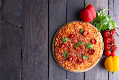 Fesleğen ve kesme tahtası ahşap arka plan üzerinde kiraz domates pizza
