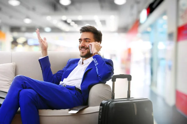 Homem de negócios com mala no hall do aeroporto — Fotografia de Stock