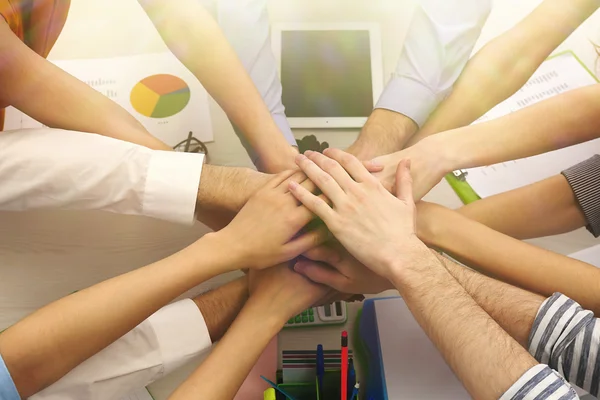 United hands of business team on workspace background top view — Stock Photo, Image