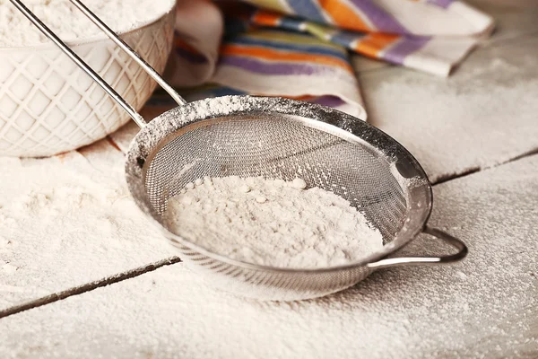 Sifting flour through sieve — Stock Photo, Image