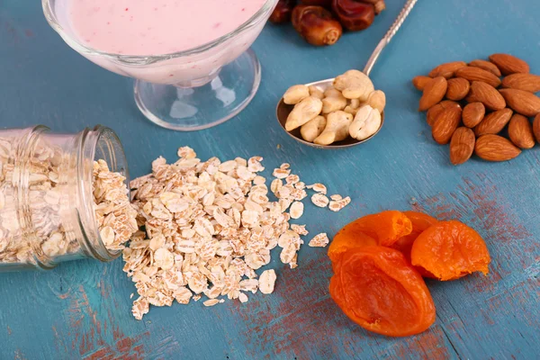 Gezond ontbijt met gedroogde vruchten en noten op een houten achtergrond kleur — Stockfoto