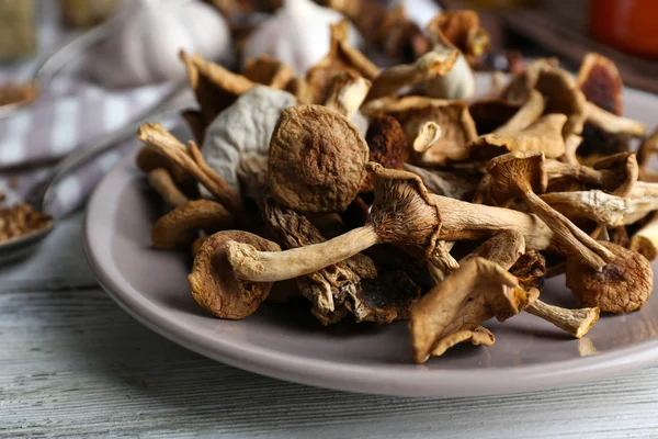 Dried mushrooms in plate on wooden table, closeup — Stock Photo, Image