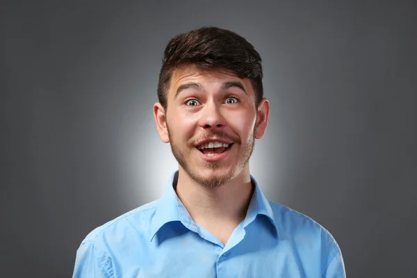 Porträt eines überraschten Mannes auf grauem Hintergrund — Stockfoto