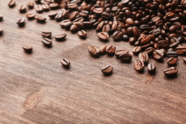 Granos de café sobre fondo de madera — Foto de Stock