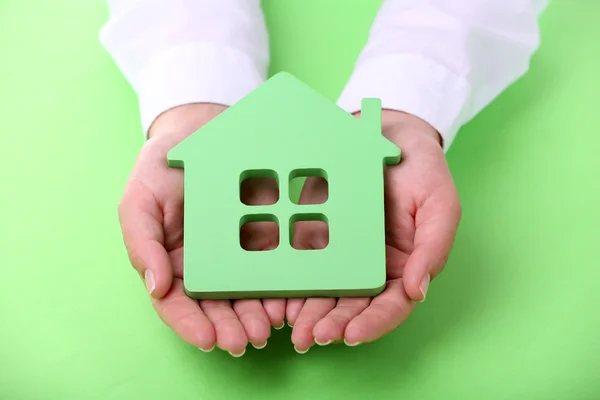 Female hands holding house on color background — Stock Photo, Image