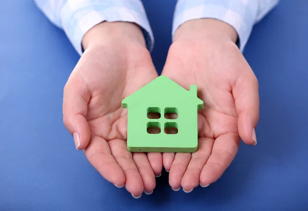 Female hands holding house on color background — Stock Photo, Image