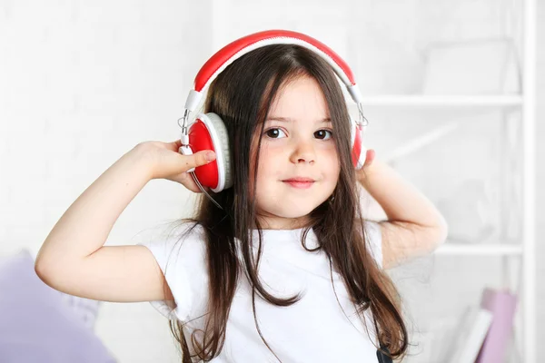 Vacker liten flicka lyssna på musik i rummet — Stockfoto