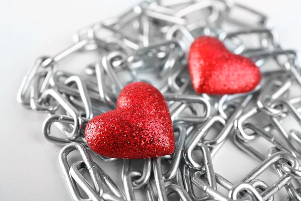 Twee rode harten met metalen ketting — Stockfoto