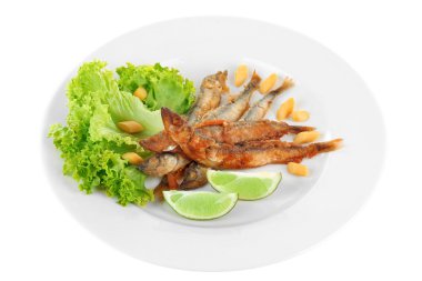 Marul ve üzerinde beyaz izole limon ile plaka üzerinde kızarmış küçük balık