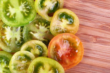 Ahşap zemin üzerine yeşil domates dilimleri