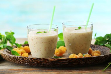 Turkuaz arka plan üzerinde ahşap masa üzerinde ahududu güler yüzlü bardak