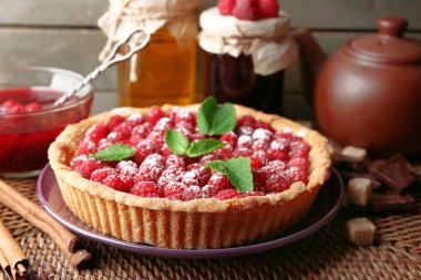 Tart ahşap arka plan üzerinde taze ahududu ile parçası