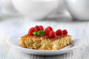 Ahududu ahşap masa, closeup üzerinde beyaz plaka ile taze pasta