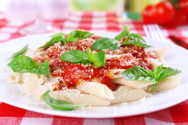 Massa com molho de tomate e manjericão na mesa de perto — Fotografia de Stock