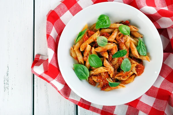 Pasta med tomatsås och basilika på bordet på nära håll — Stockfoto