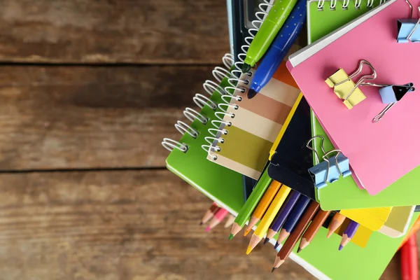 Pila di libri e cancelleria su sfondo di legno — Foto Stock