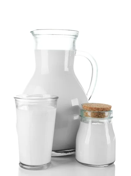 Jarra, jarra y vaso de leche sobre mesa de madera, sobre fondo blanco —  Fotos de Stock