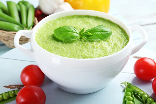 Tasty peas soup and vegetables on table close up — Stock Photo, Image