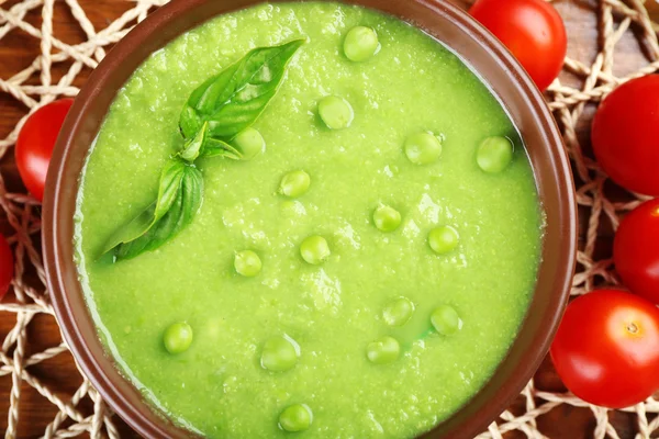 Tasty peas soup and cherry tomatoes on table close up — Stock Photo, Image