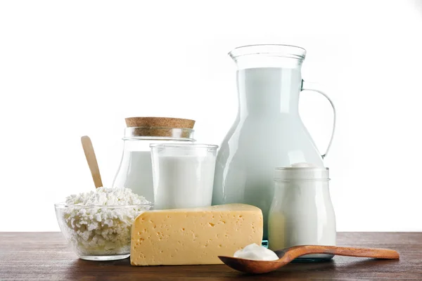 Produtos lácteos em mesa de madeira sobre fundo branco — Fotografia de Stock