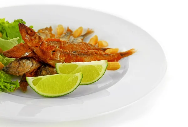 Fried small fish with lettuce and lime on plate close up — Stock Photo, Image