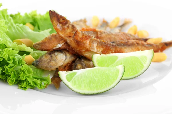 Pequeno peixe frito com alface e limão no prato de perto — Fotografia de Stock