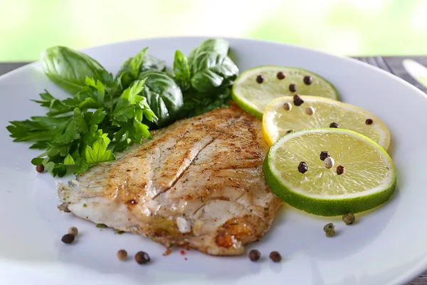 Plato de filete de pescado con verduras y lima en la mesa de cerca — Foto de Stock