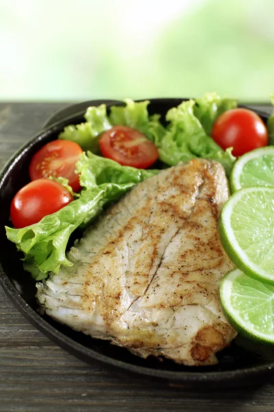 Fischfilet mit Salat und Limette auf hellem Hintergrund — Stockfoto