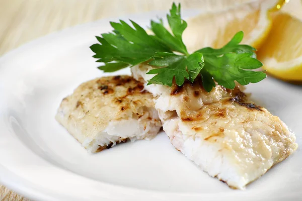 Plato de filete de pescado con verduras y limón en el plato de cerca — Foto de Stock