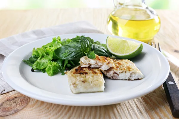 Schotel van visfilet met Groenen en kalk op tafel close-up — Stockfoto