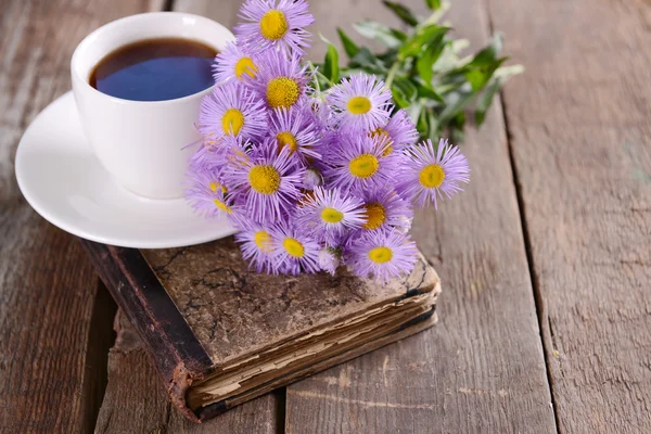 Книга з квітами і чашкою чаю — стокове фото