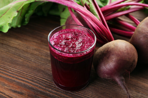 Свекольный сок с овощами на столе
