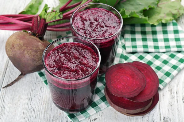 Glasses of beet juice with vegetables on table close up — Stock Photo, Image