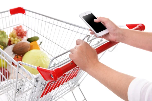 Jovem segurando telefone celular e carrinho de compras de perto — Fotografia de Stock