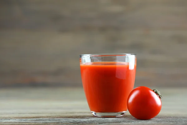 Glas tomatjuice med grönsaker på träbord nära håll — Stockfoto