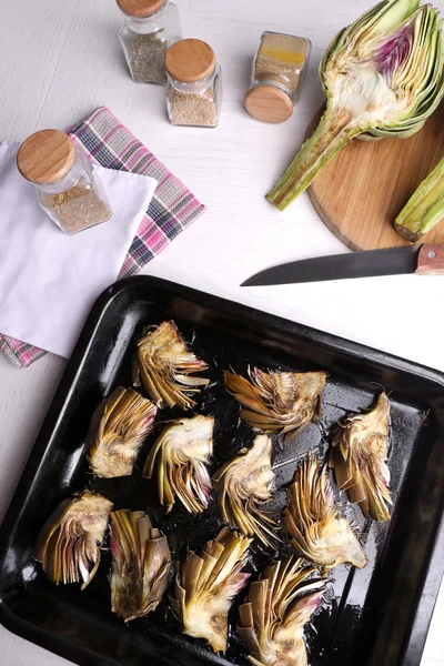 Alcachofas asadas en sartén, sobre fondo de mesa de cocina — Foto de Stock