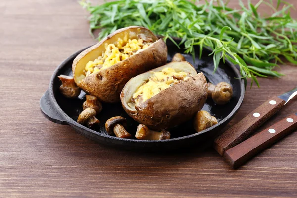 Batatas assadas com queijo e cogumelos na mesa de perto — Fotografia de Stock