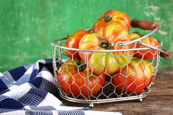 Green tomatoes in basket on wooden background — Stock Photo, Image