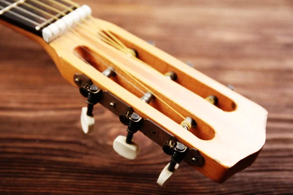 Pescoço de guitarra acústica em fundo de madeira — Fotografia de Stock