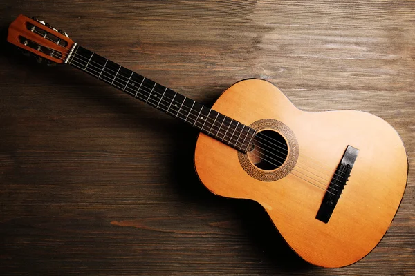 Акустическая гитара на деревянном фоне — стоковое фото