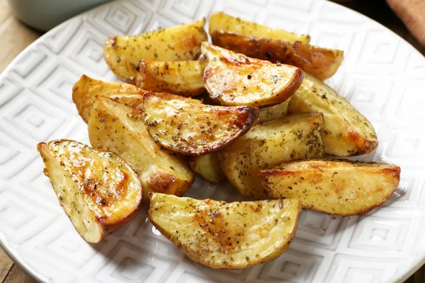 Gebakken pittige aardappelen op witte plaat, close-up — Stockfoto