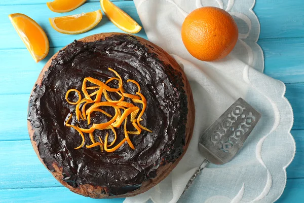 Bolo com Chocolate Glaze e laranja na cor de fundo de madeira — Fotografia de Stock