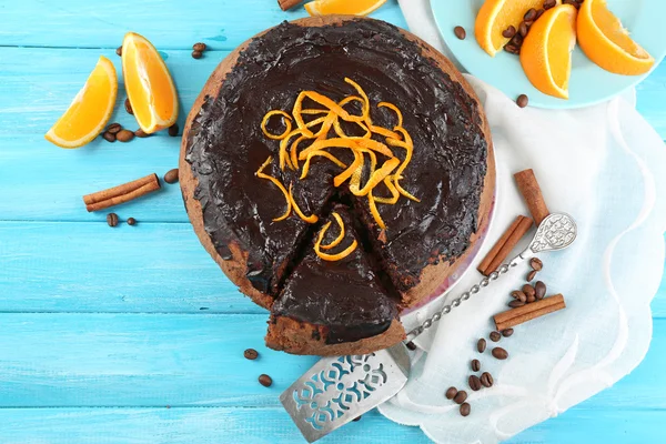 रंग लाकडी पार्श्वभूमीवर चॉकलेट ग्लेझ आणि संत्रासह केक — स्टॉक फोटो, इमेज