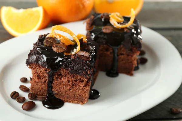 Portion of Cake with Chocolate Glaze and orange on plate, close-up — Stock Photo, Image