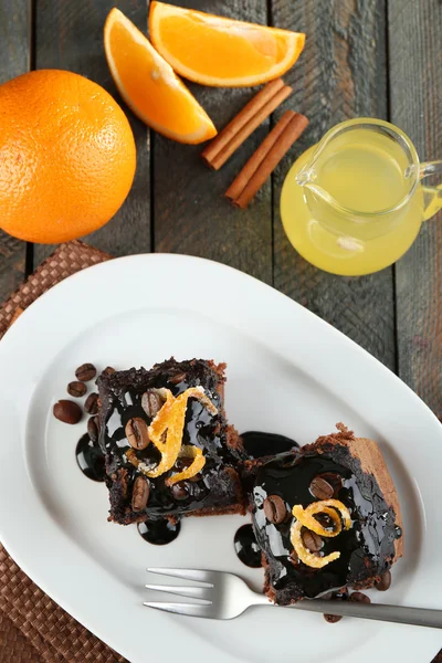 Portion of Cake with Chocolate Glaze and orange on plate, on wooden background — Stock Photo, Image