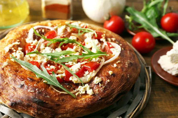 Greek homemade pizza with ham,onion, roasted tomato, creamy feta on wooden table background — Stock Photo, Image