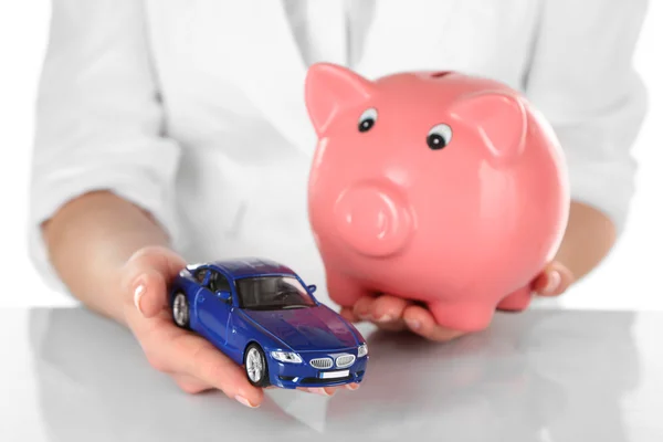 Woman holding model of car and piggy bank close up — Stock Photo, Image